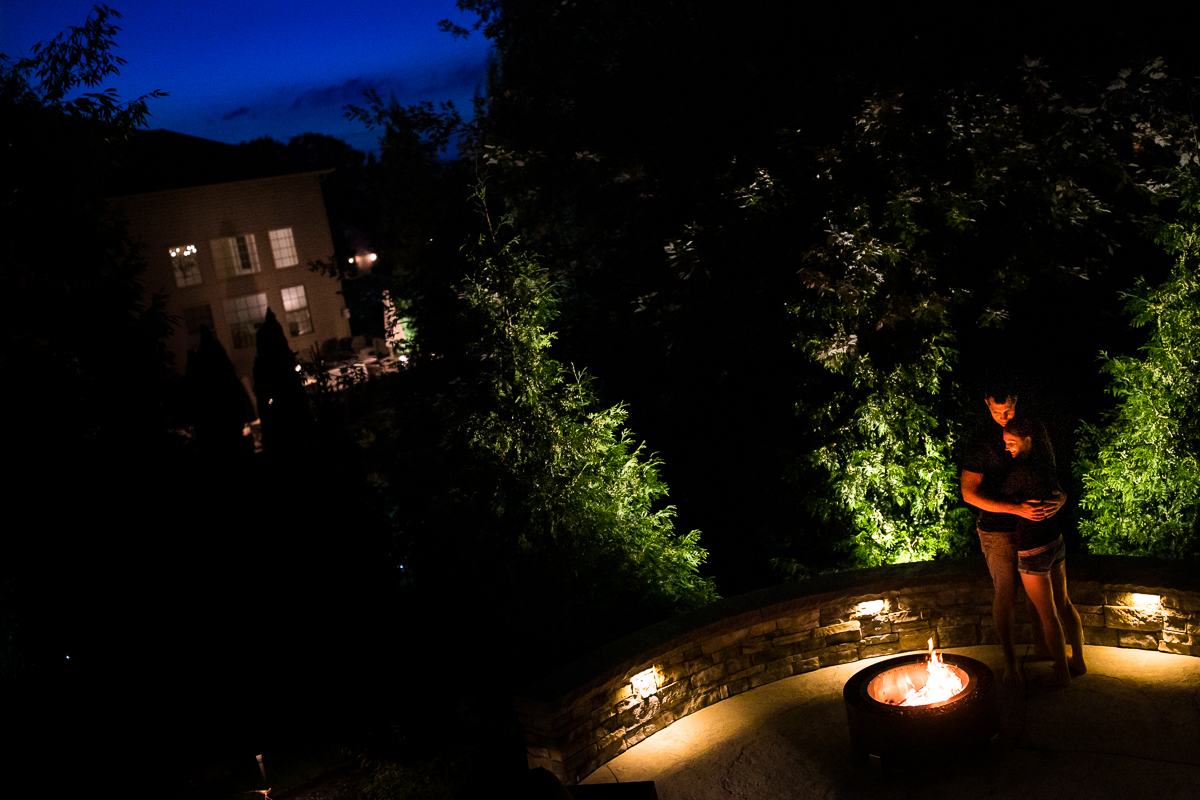 couple standing in front of fire pit embracing at their home central pa lifestyle photographer