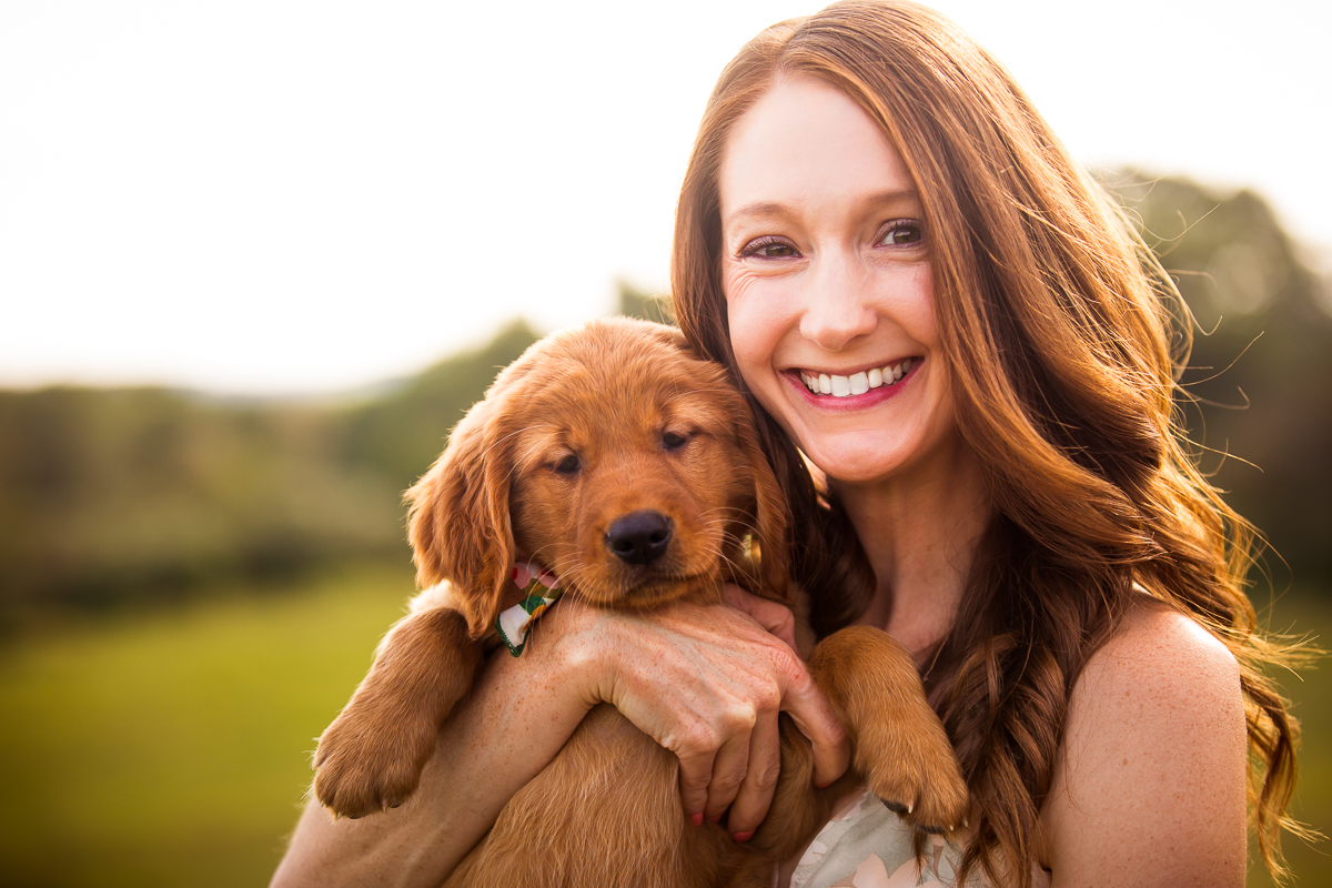 joyful lifestyle family photographer woman holding puppy outside smiling 