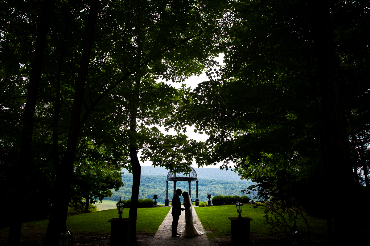 best award winning creative wedding photographer stroudsmoor ridgecrest first look bride and groom standing on path silhouetted with trees behind and surrounding them