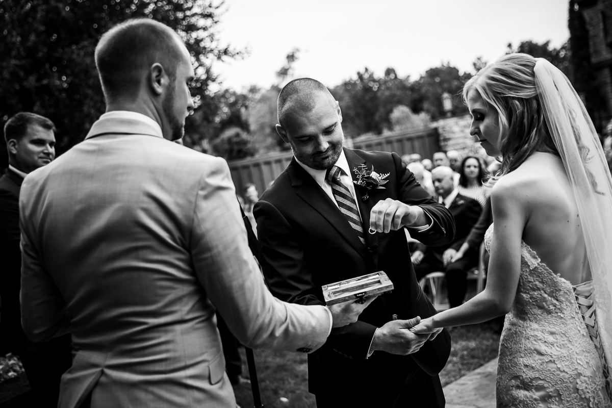 Stroudsmoor Terraview wedding ceremony black and white photo of groom grabbing ring from box to put on bride's hand during exchange of vows