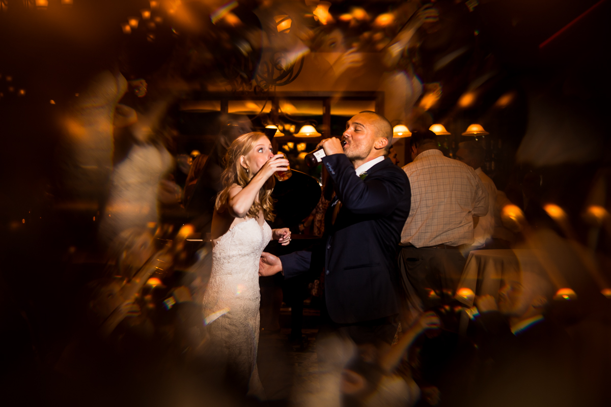 creative artistic wedding photographer bride and groom drink together during reception at stroudsmoor country inn