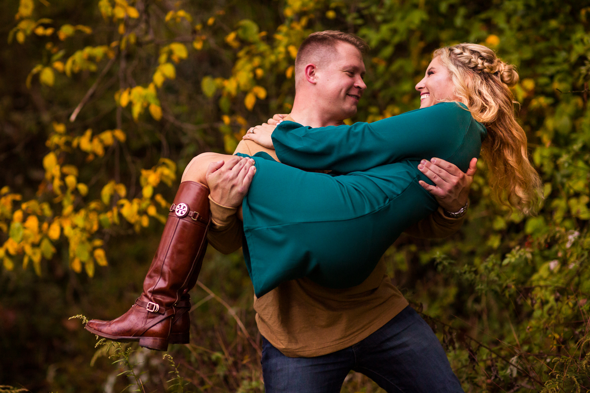 Blairstown nj engagement photographer guy picking girl up smiling at each other outside