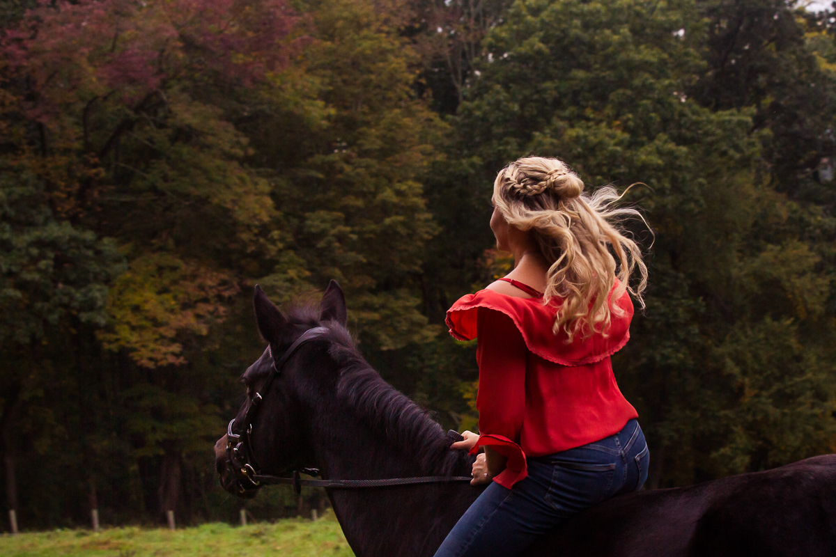 nj horseback riding engagement session girl in red riding horse at barn in nj best engagement photographer central pa