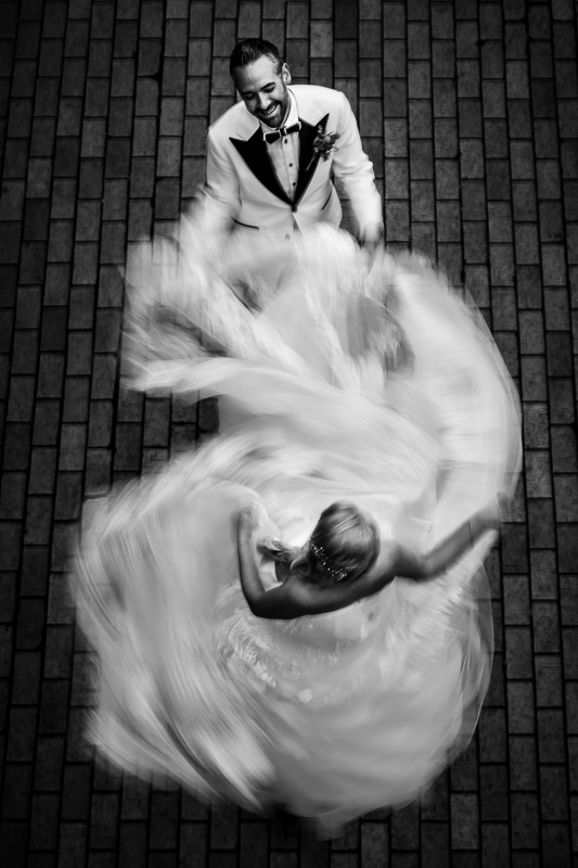black and white photo of bride spinning in her dress slow motion groom smiling best creative artistic unique wedding after-session photographer