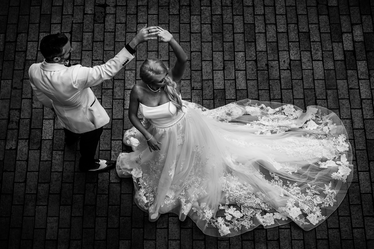 black and white photo of groom twirling bride on brick pavement best creative unique artistic central pa wedding engagement photographer