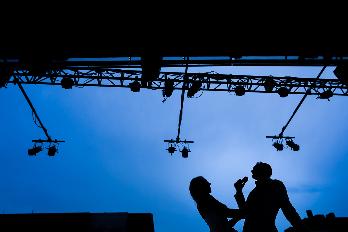 creative artistic unique vibrant blue sky silhouettes bride and groom singing shallow on steelstacks stage