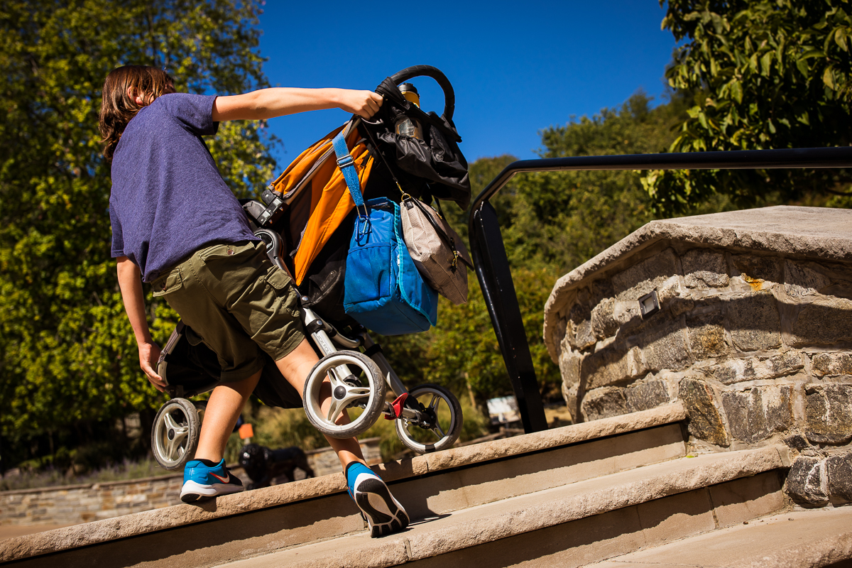 boy carrying stroller up stairs at Maryland zoo authentic candid family photographer central pa