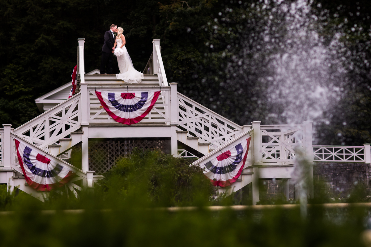 Omni Bedford Springs wedding photographer artistic creative couple kisses with fountain in front of them award winning