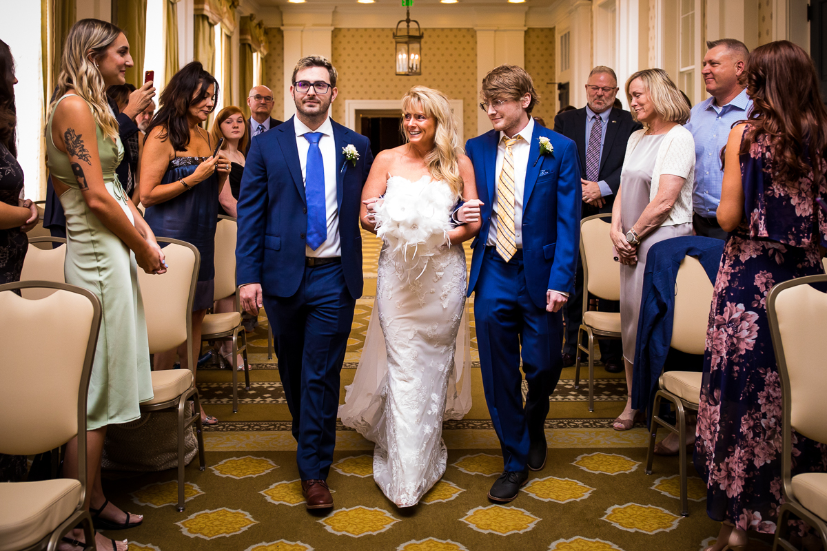 bride walking down the aisle with two sons in constitution hall wedding ceremony