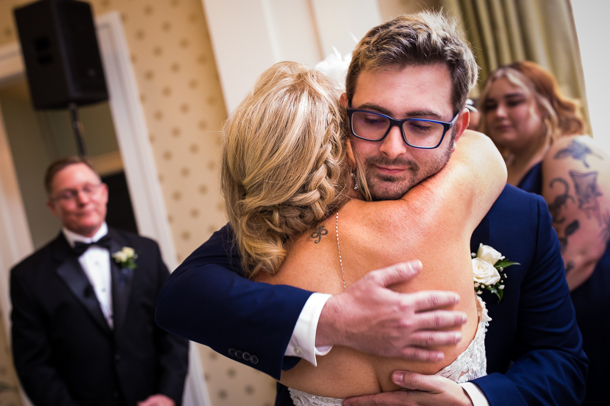 son hugs mom before wedding ceremony begins emotional authentic wedding photographer