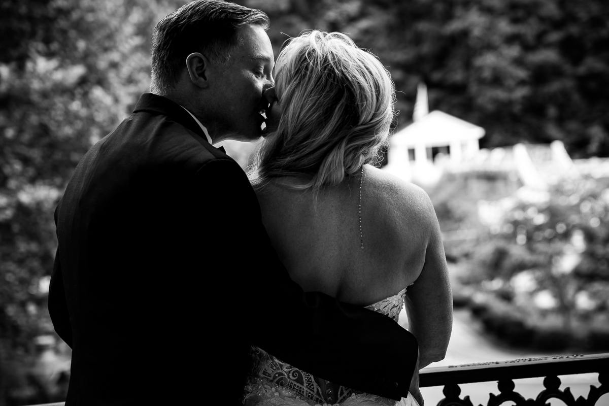 black and white photo Omni Bedford Springs wedding photographer couple sharing a kiss on grounds of omni