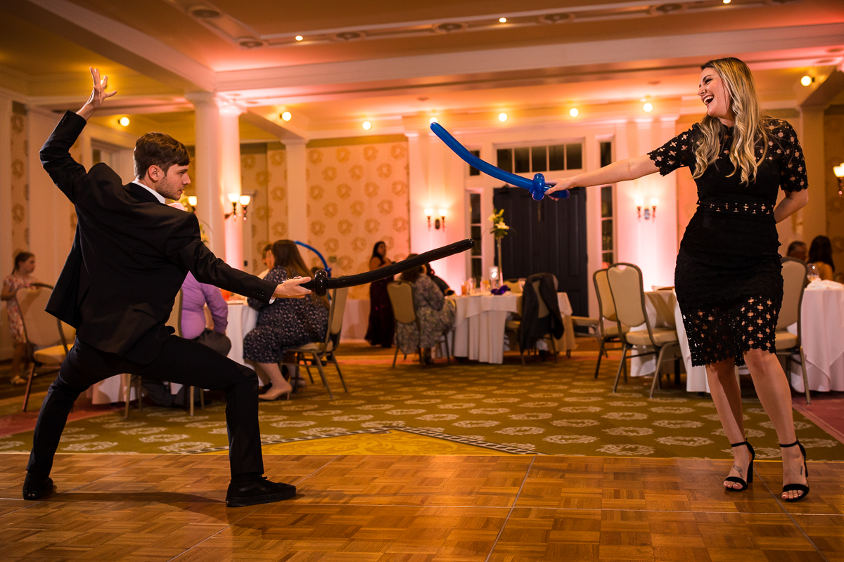Omni Bedford Springs wedding photographer boy and girl pointing swords at each other during wedding reception