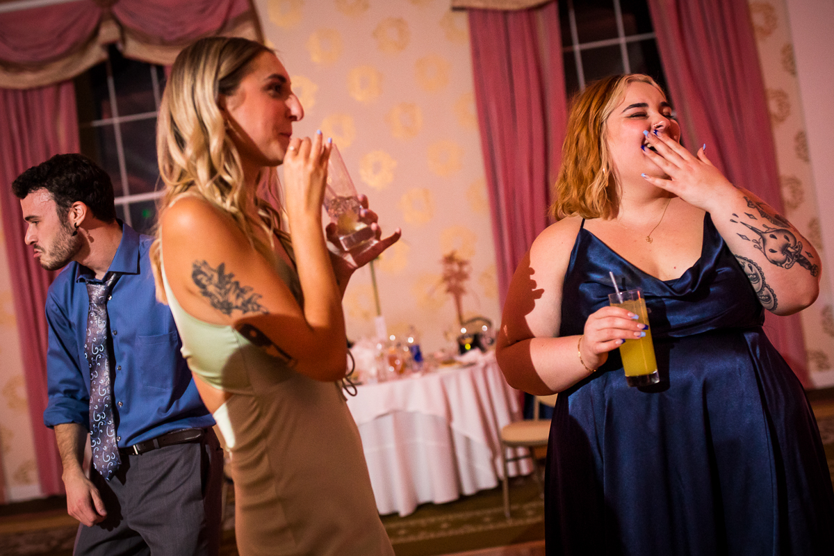 wedding guests drink and laugh on dance floor