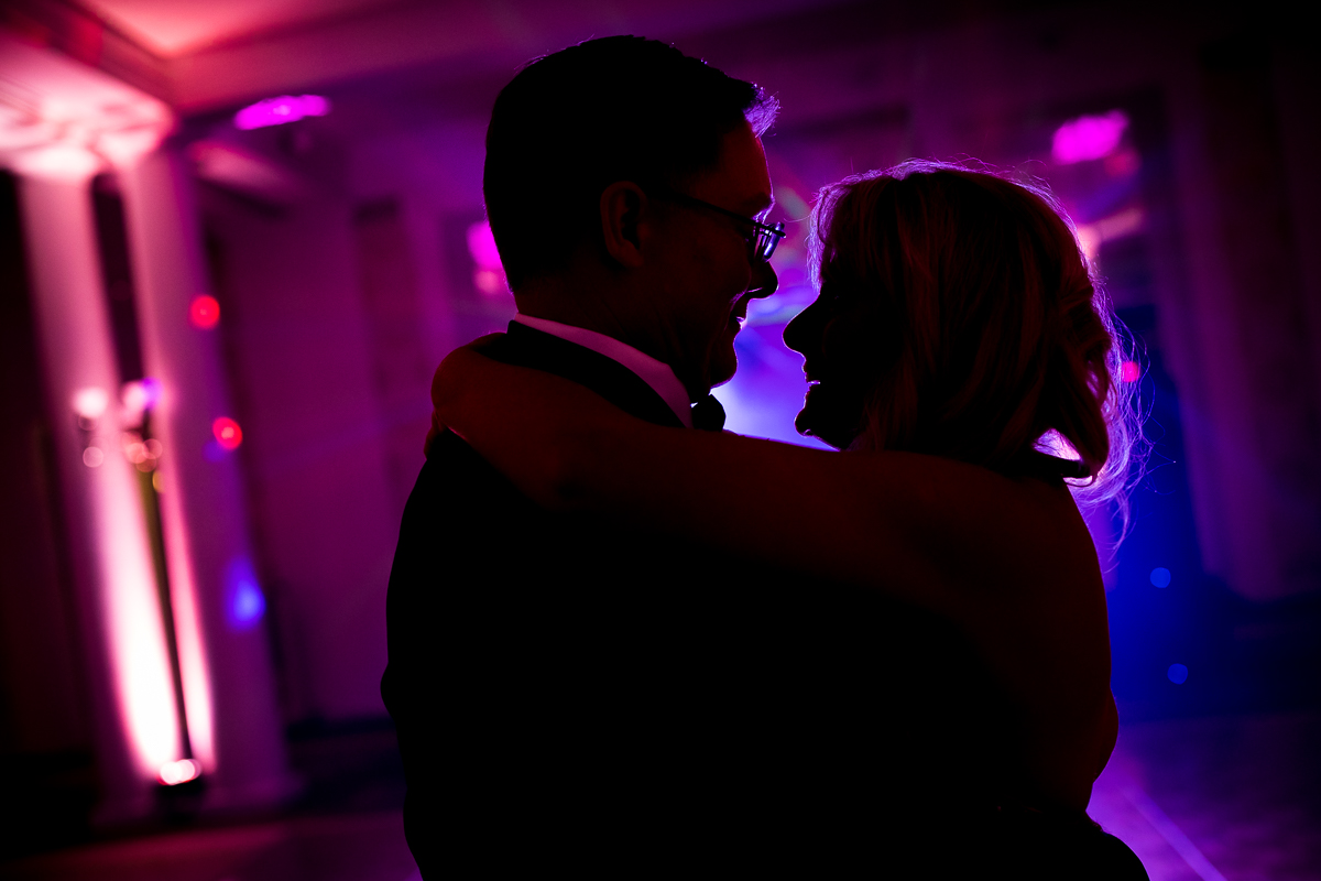 vibrant colorful creative best wedding photographer Omni Bedford Springs couple dancing silhouetted against uplighting in reception