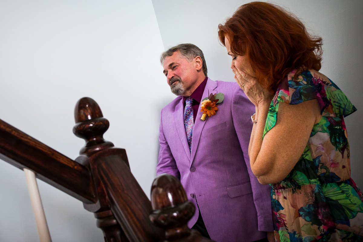 parents waiting at bottom of stairs for bride to come down for first look