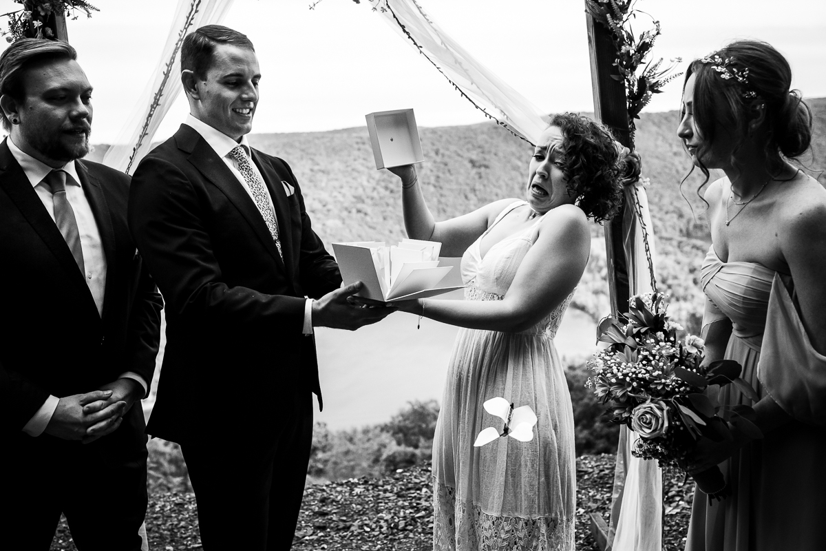 black and white photo of bride opening box of butterflies to release after ceremony