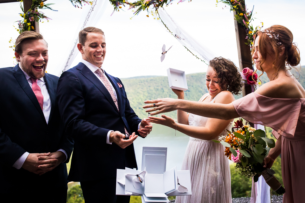 raystown lake wedding photographer bride opening box of butterflies while guests smile