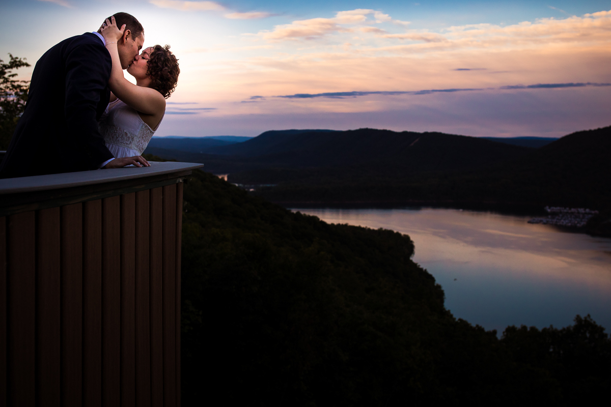 creative artistic vibrant couple kissing with sunset in background at raystown lake 