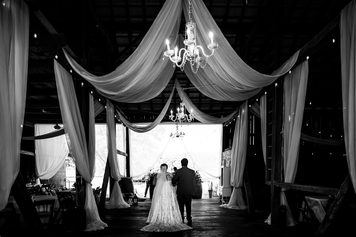 black and white phot of bride with father inside heritage restored before walking down the aisle to ceremony 