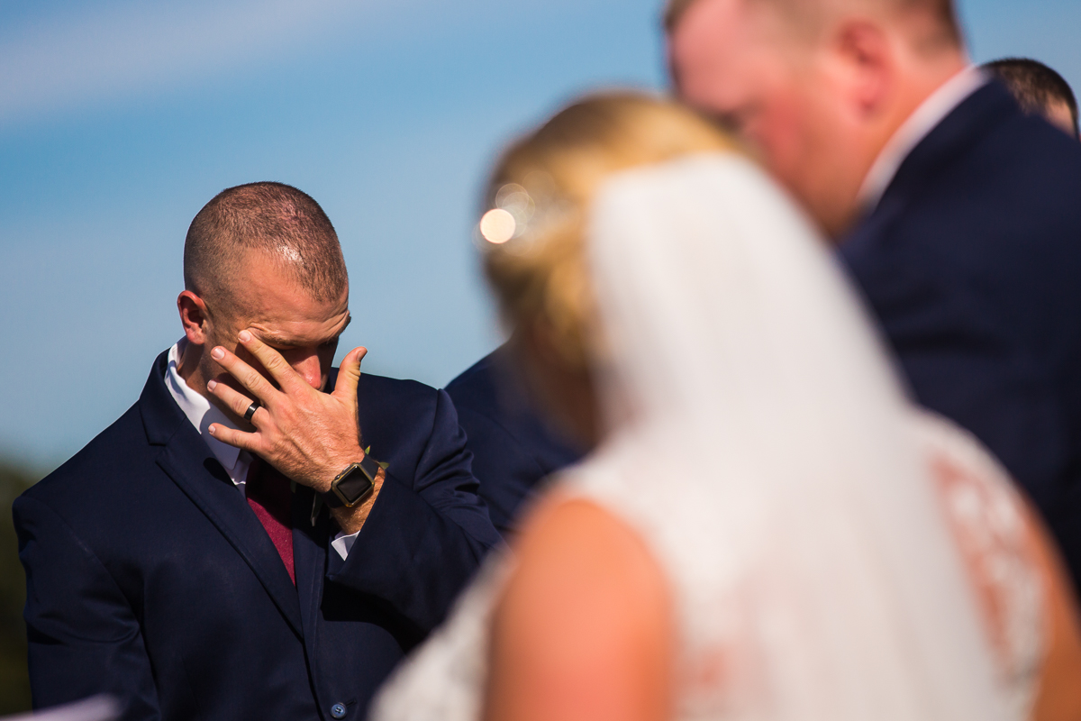 best man wiping tear away during wedding reception