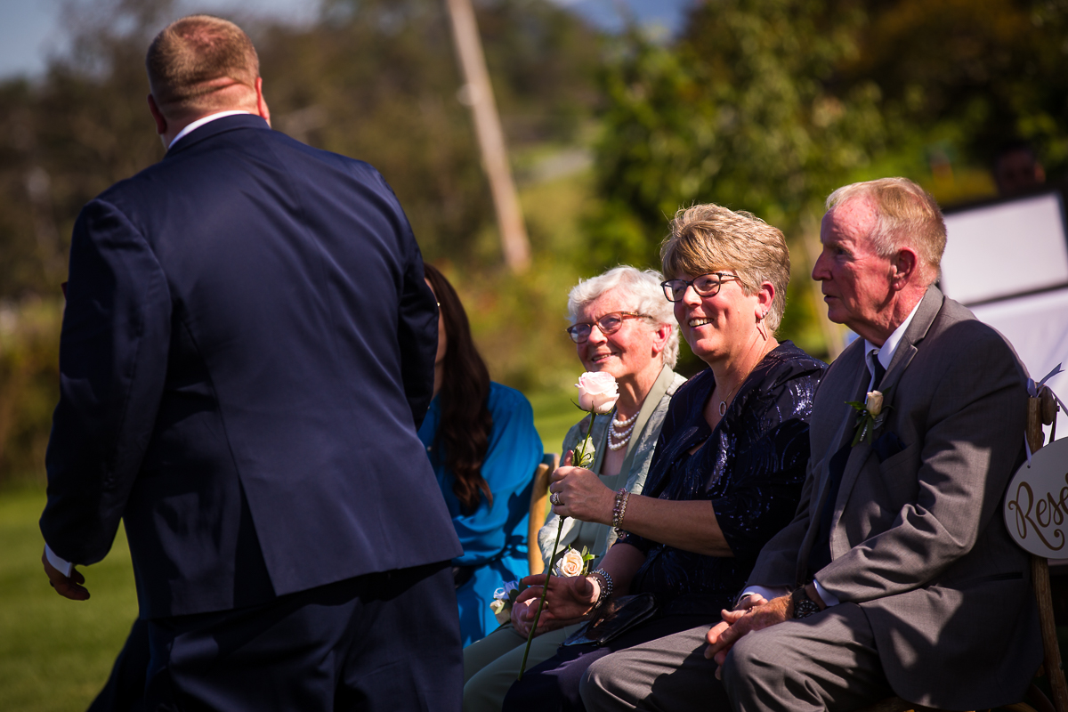 groom giving mom rose during wedding ceremony