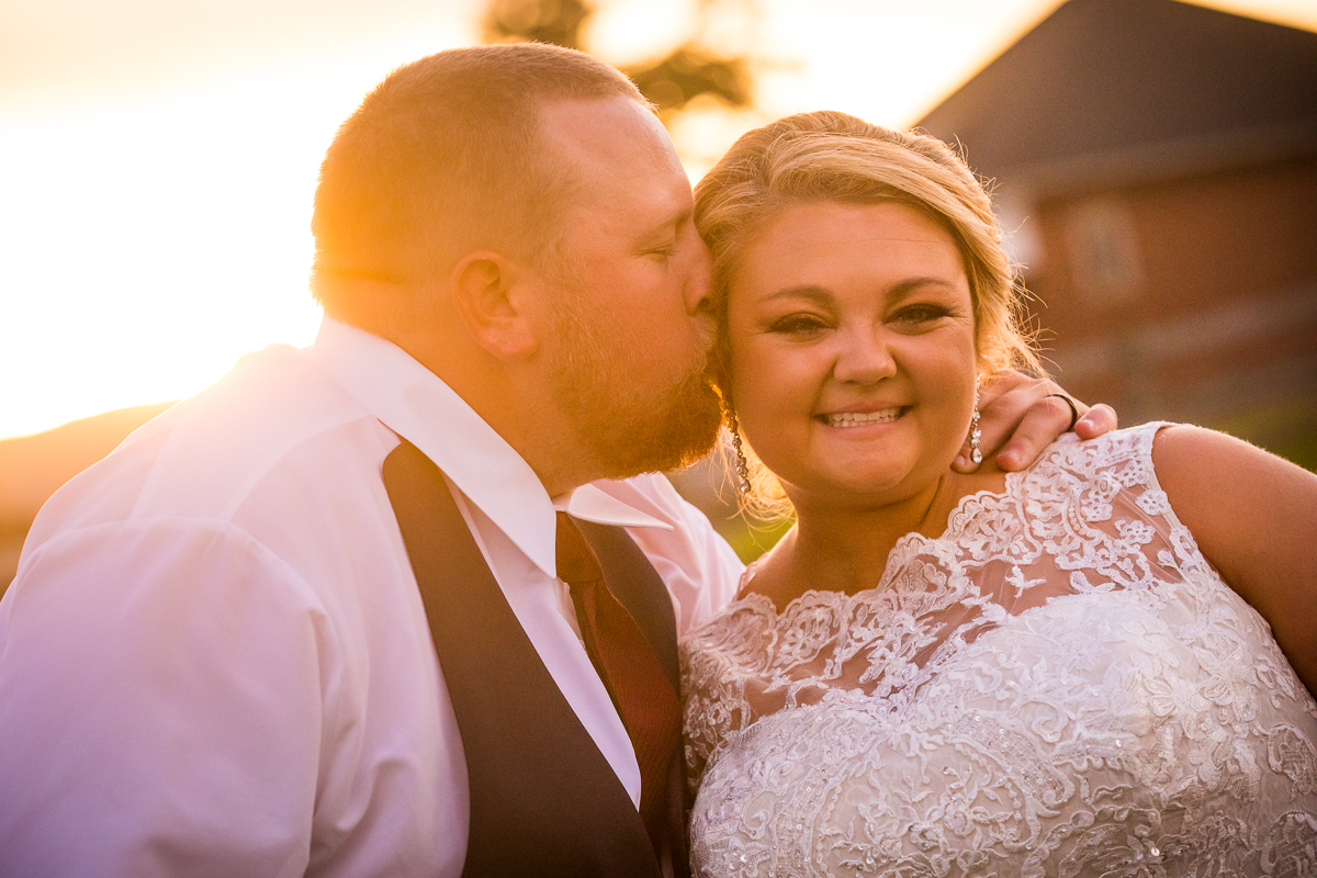 artistic creative central pa wedding photographer groom kissing bride on cheek during golden hour