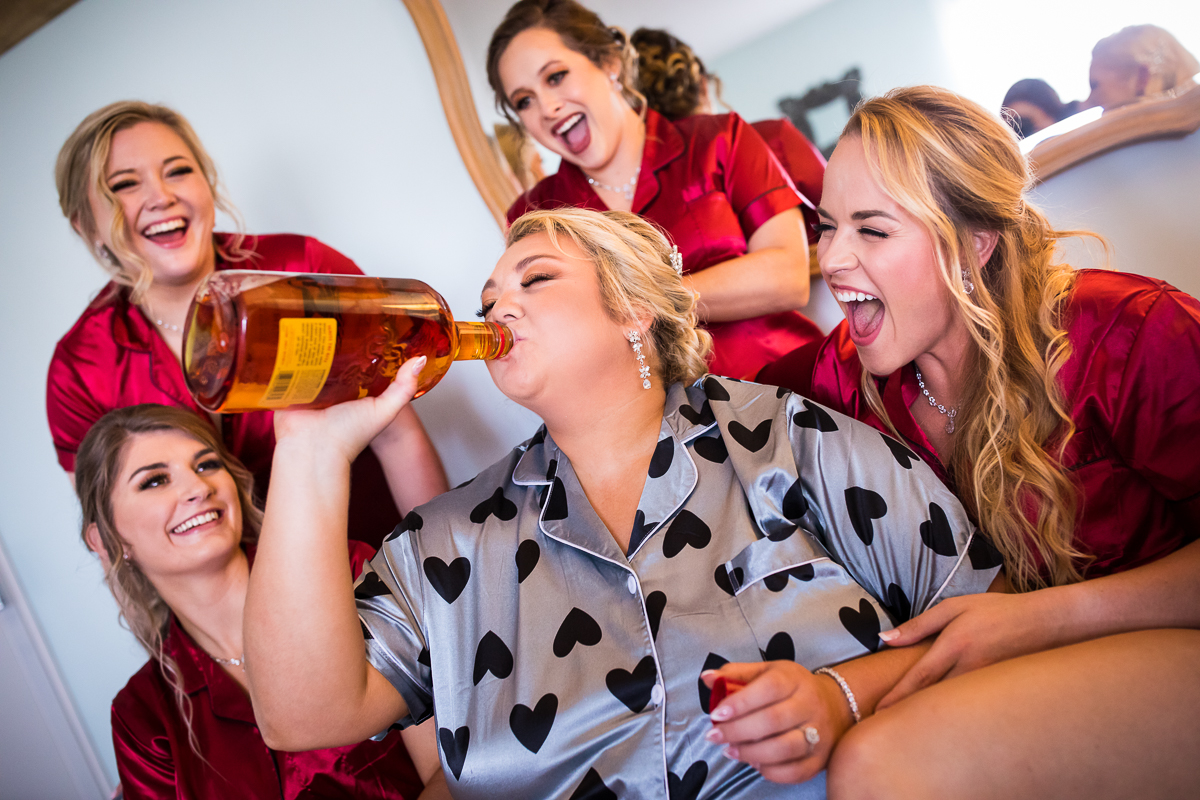 bride and bridesmaid drinking fireball during getting ready at heritage restored bridal suite authentic candid real life central pa wedding photographer 
