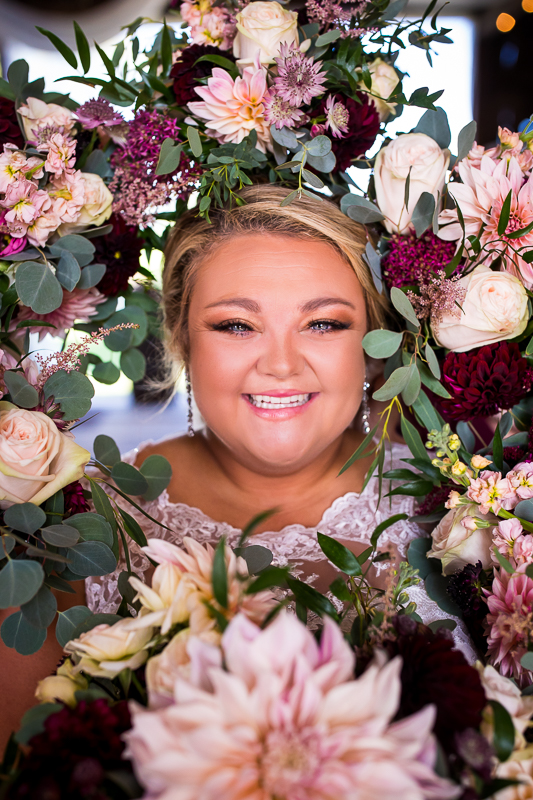 bride smiling surrounding by bridesmaids bouquets at heritage restored
