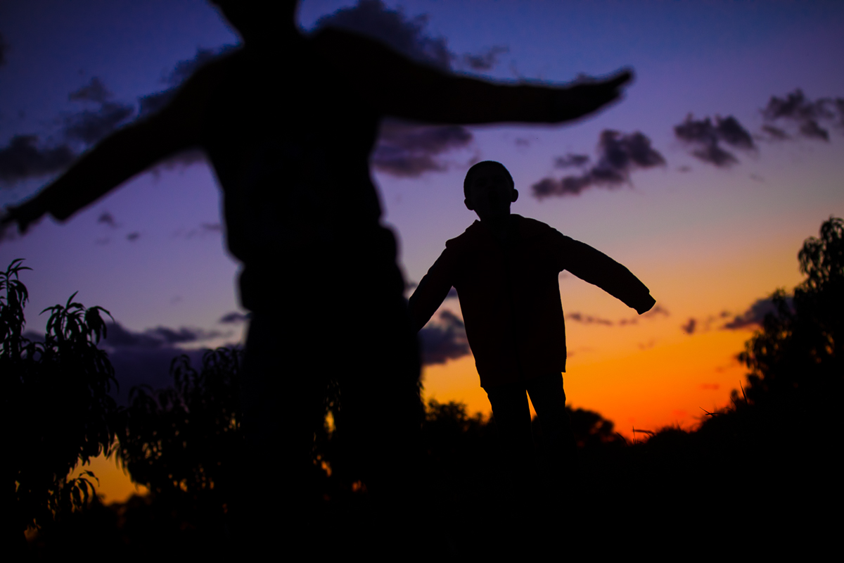 creative artistic central pa family lifestyle session two boys standing with arms out against sunset silhouetted