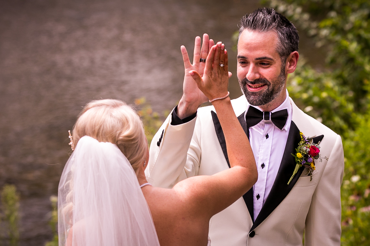 bride and groom high fiving after seeing each other at first look