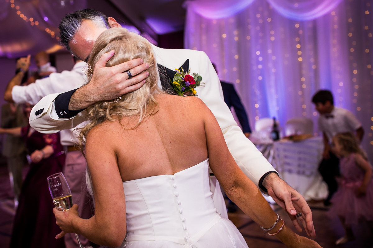 bride and groom kissing groom holding back of bride's head wearing wedding ring Hollywood inspired wedding