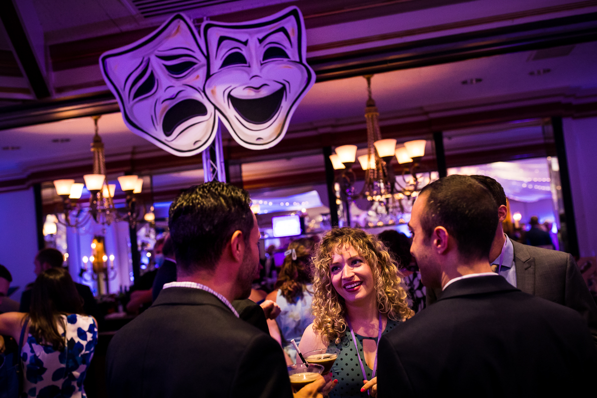guests talking during cocktail hour theater mask decor Hollywood inspired wedding
