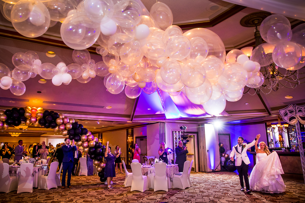creative authentic vibrant Lehigh Valley wedding photographer bride and groom announced into ballroom cloud of balloons and balloon arch Lehigh Valley conference center