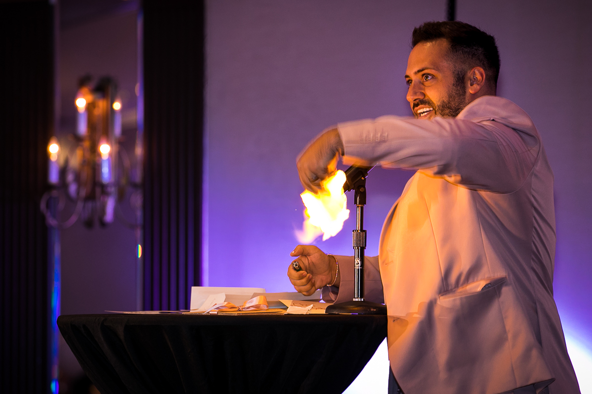 groomsmen performing fire magic trick at wedding reception