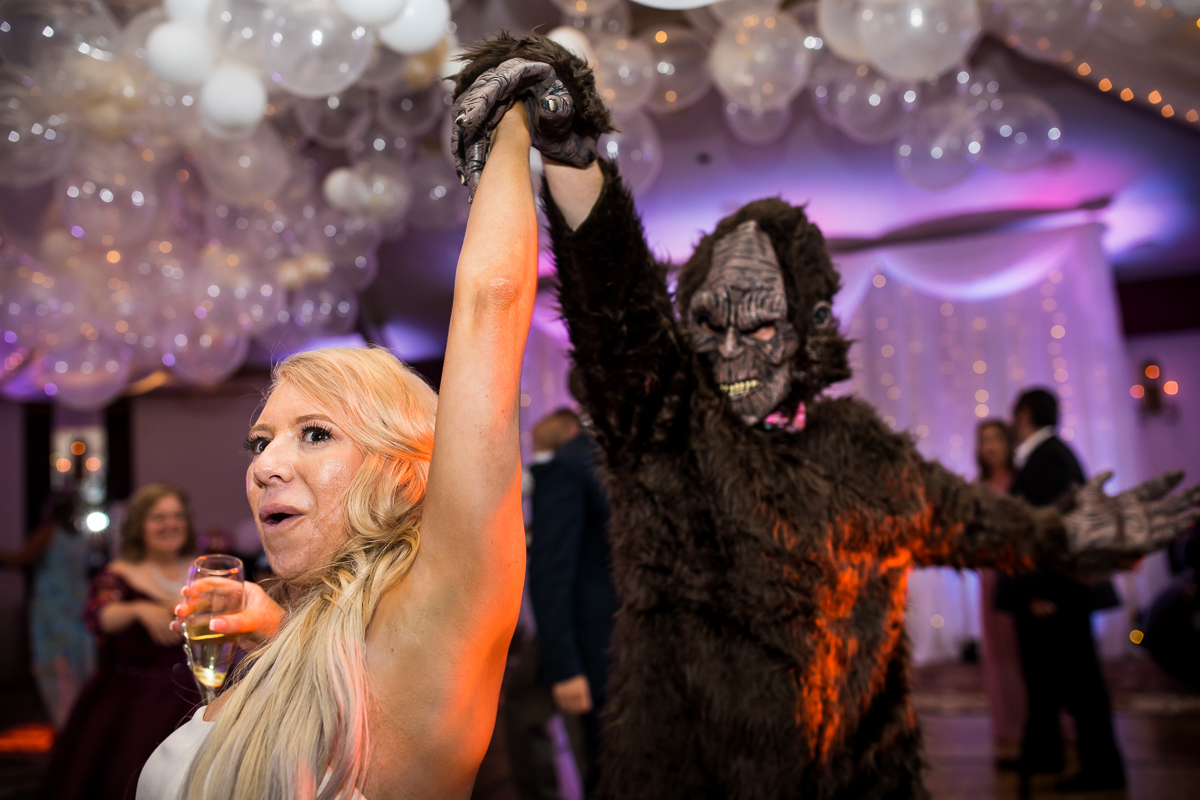 bride being twirled by gorilla costume person