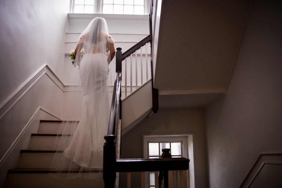 bride walking up stairs for first look with dad 