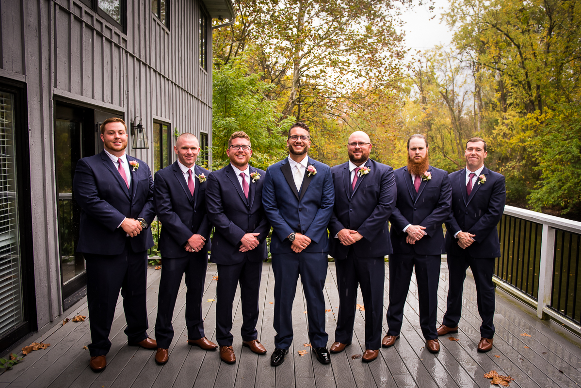 groom and groomsmen smiling together before ceremony outside allenberry resort