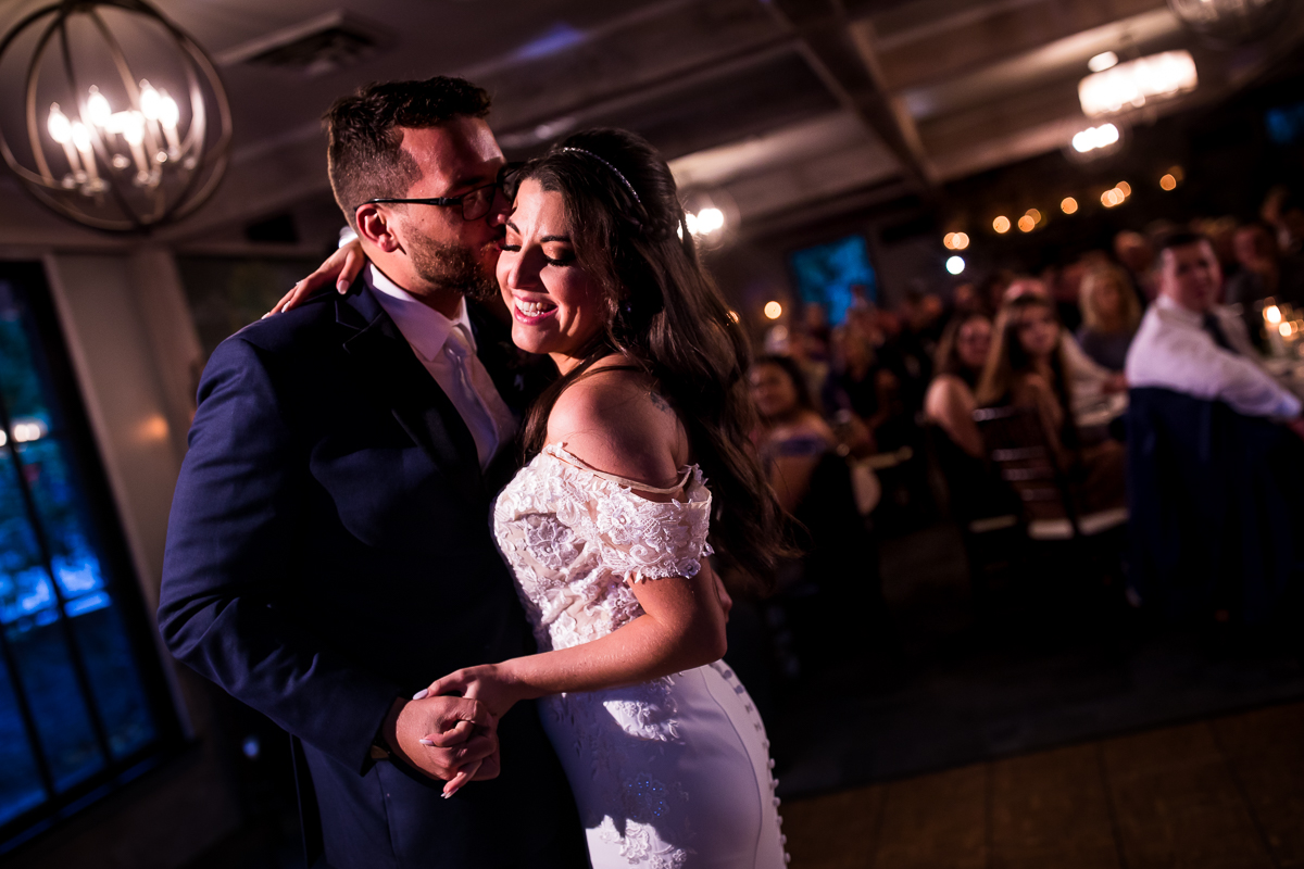groom kissing bride on cheek during emotional first dance at allenberry resort wedding reception carriage house