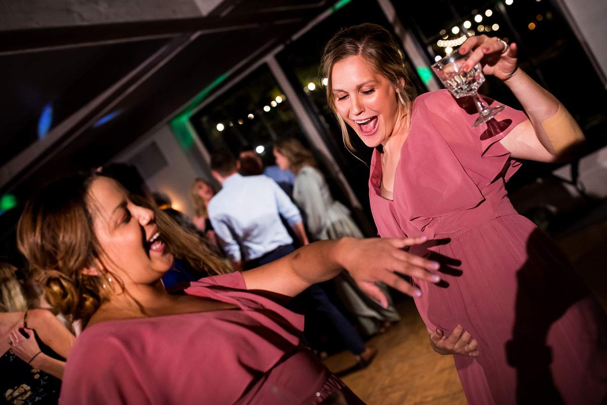 pregnant bridesmaid dancing on dance floor during wedding reception