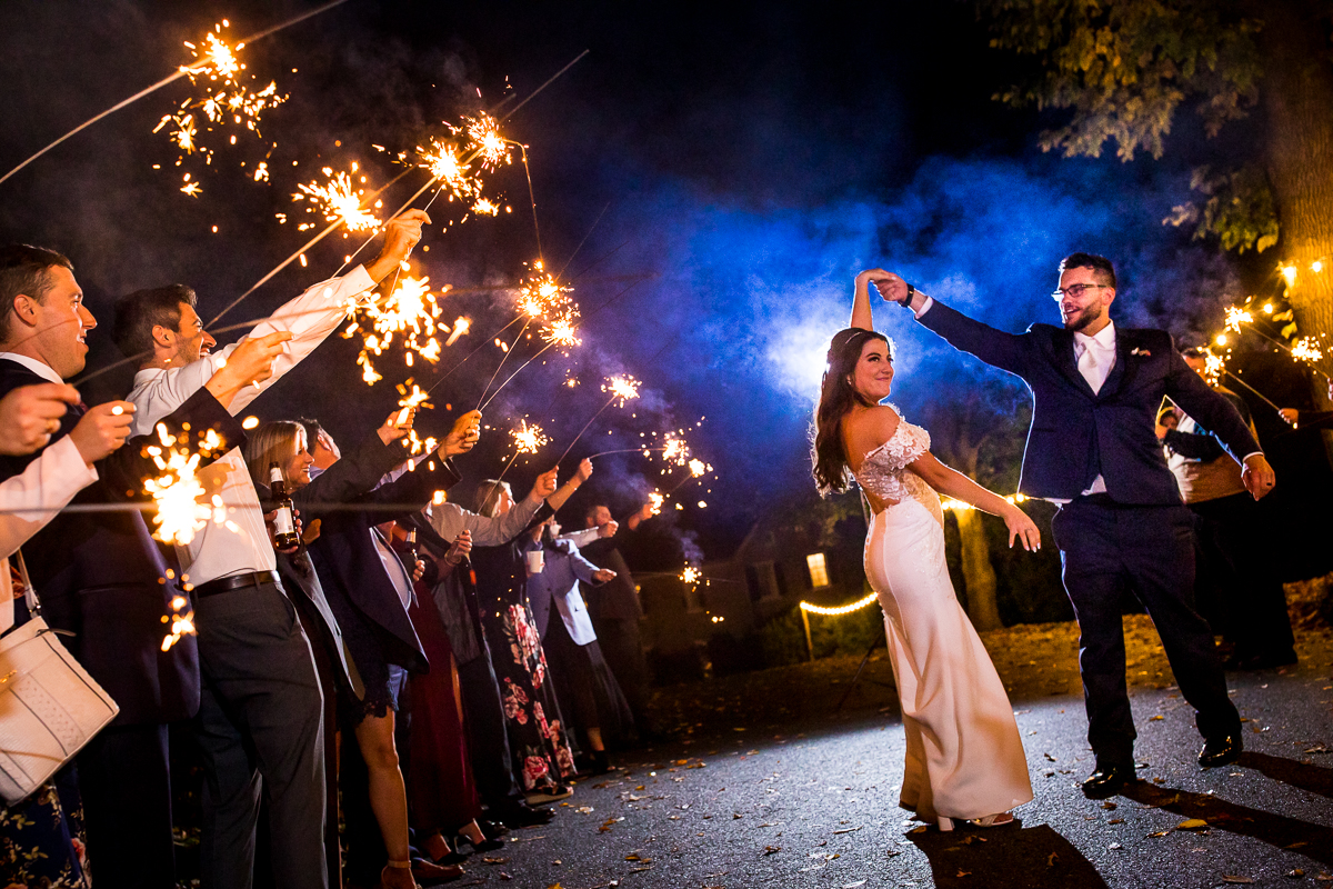 creative artistic allenberry resort wedding photographer groom spinning bride while guests show sparklers around them