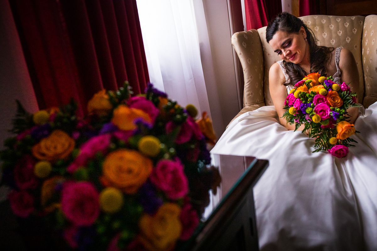 bride smiling looking down at colorful bouquet after getting ready artistic creative best central pa wedding photographer