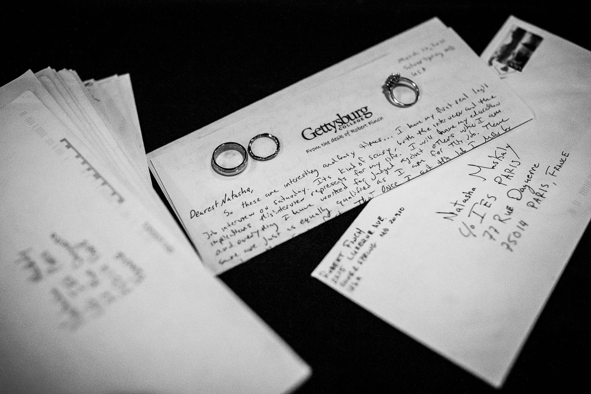 black and white photos of bride and groom letters written to each other with rings on top