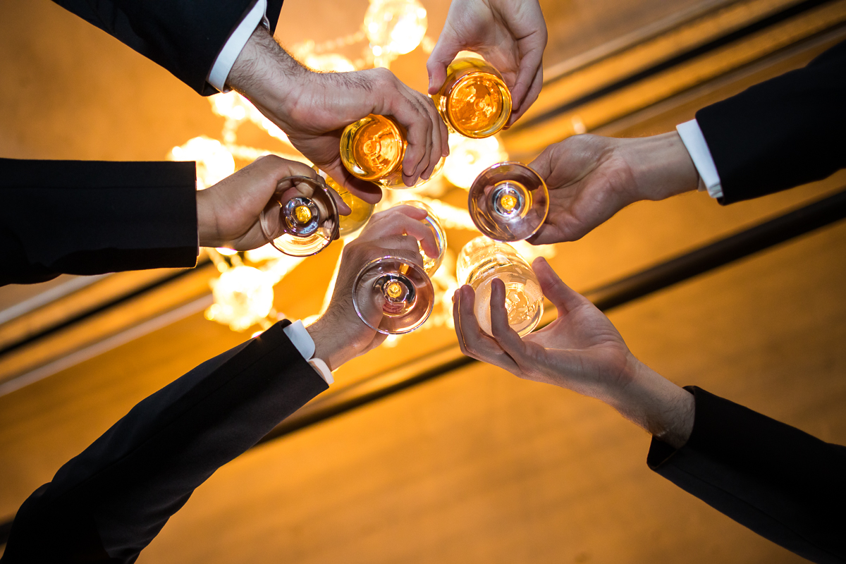 creative artistic photo of groom and groomsman toasting during getting ready 