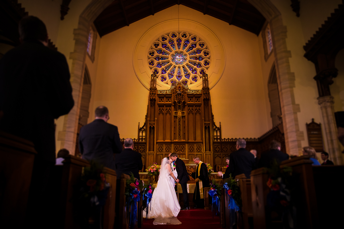 bride and groom share first kiss as husband and wife at methodist church altar york pa