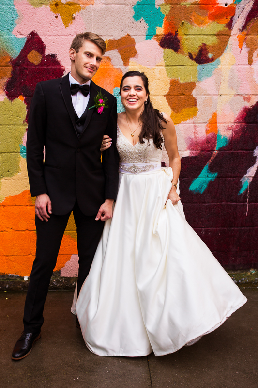bride and groom smiling at camera in front of the york square murals downtown york pa central pa wedding photographer 