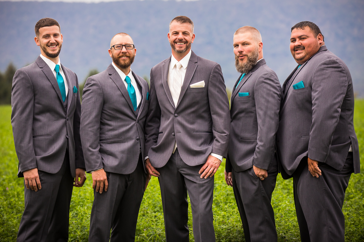 groom and groomsmen standing smiling at camera outside Newburg pa wedding photographer