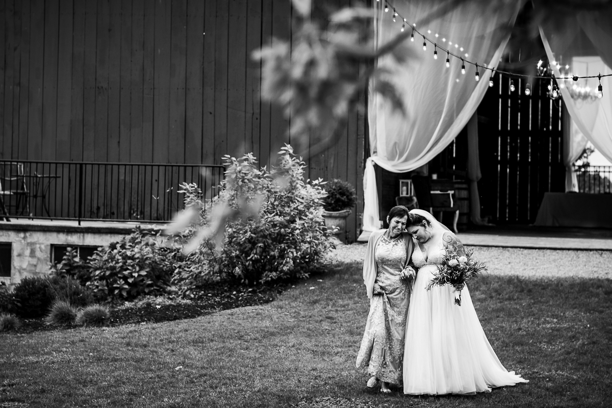 black and white emotional authentic real life photo of bride walking with mom to ceremony