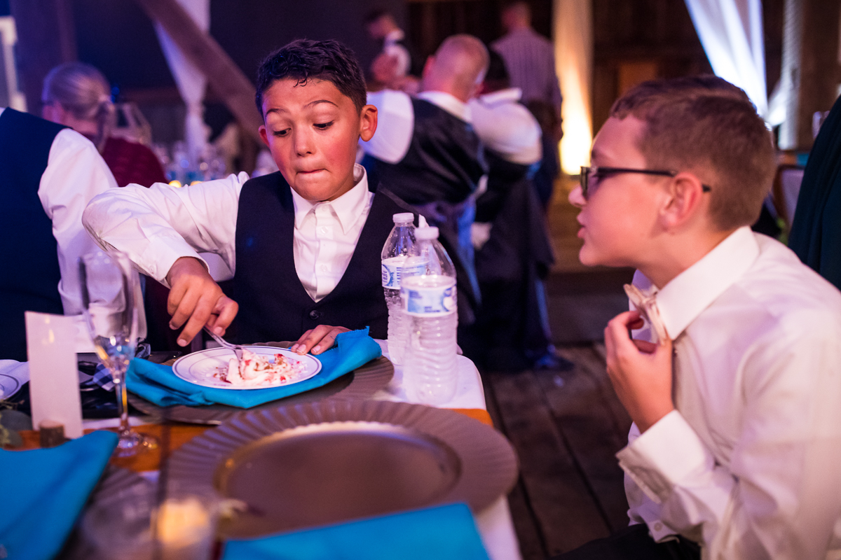 two boys eating dessert during wedding reception