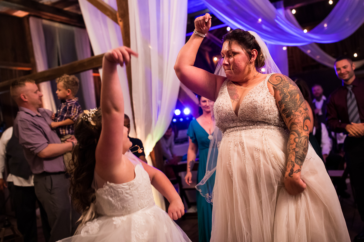 bride dancing with daughter during wedding reception 