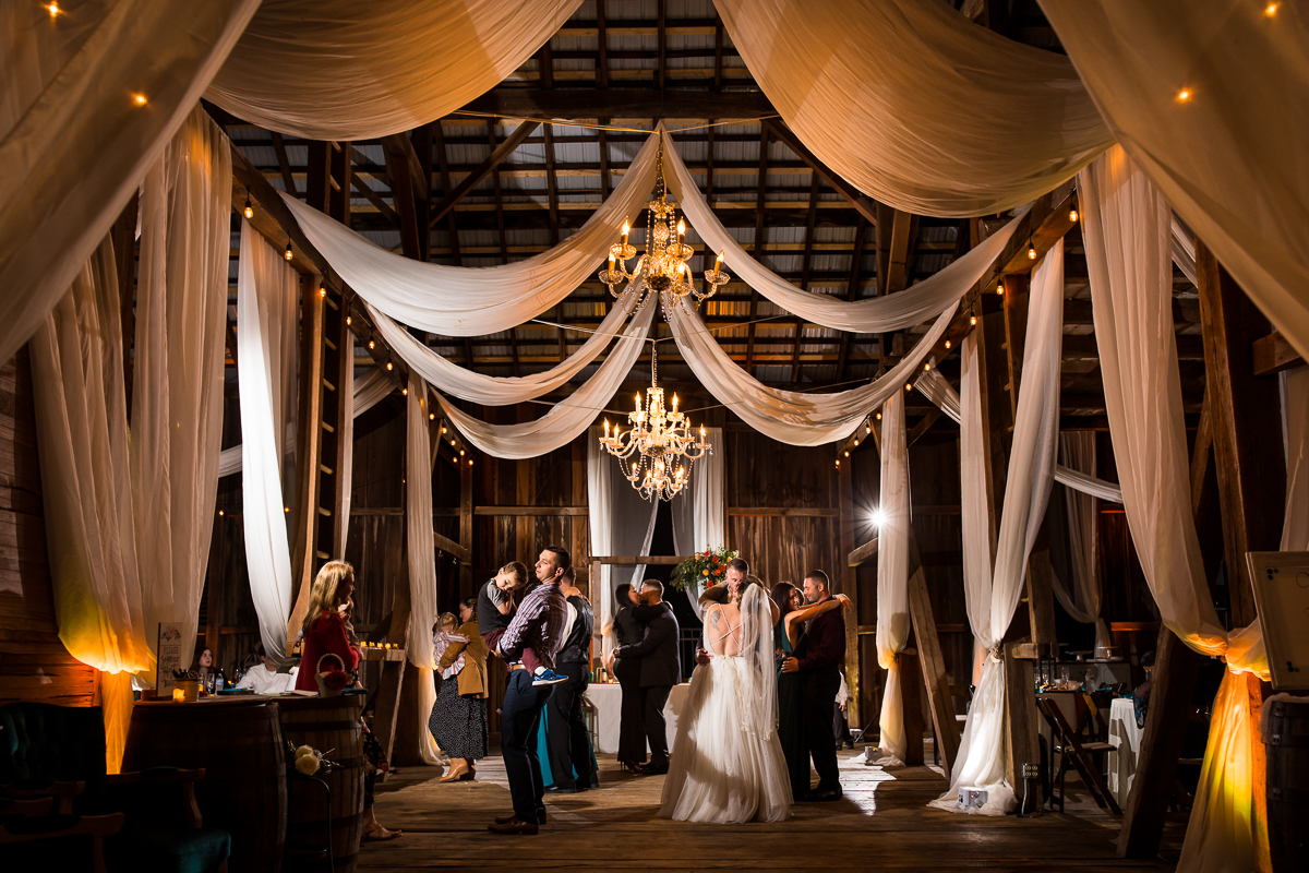 heritage restored wedding reception bride and groom dancing under drapery and chandelier 